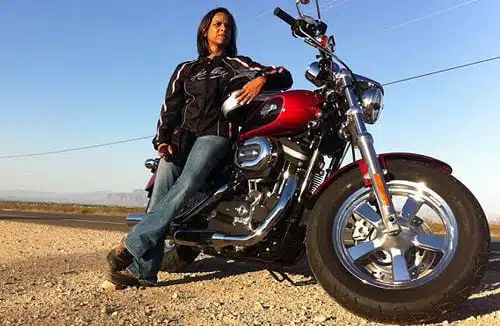 woman leaning on red harley davidson