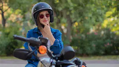contact us for more information woman thinking on motorbike